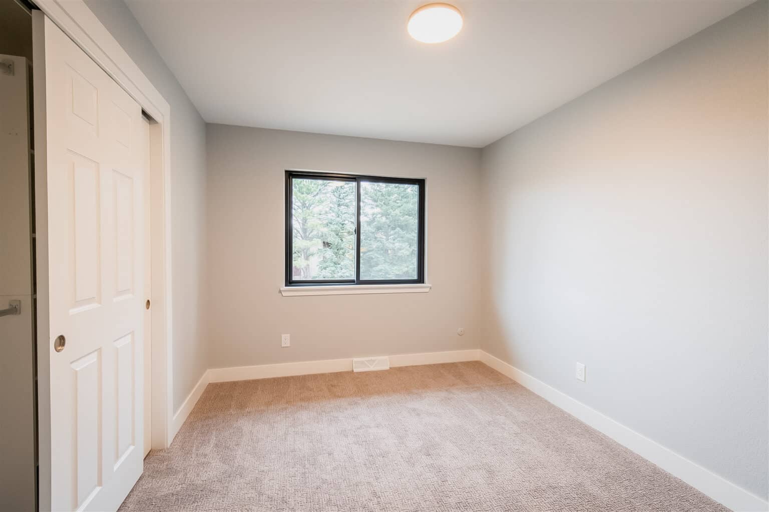 Newly remodeled room in a Colorado home with newly installed windows, flooring, and closets.