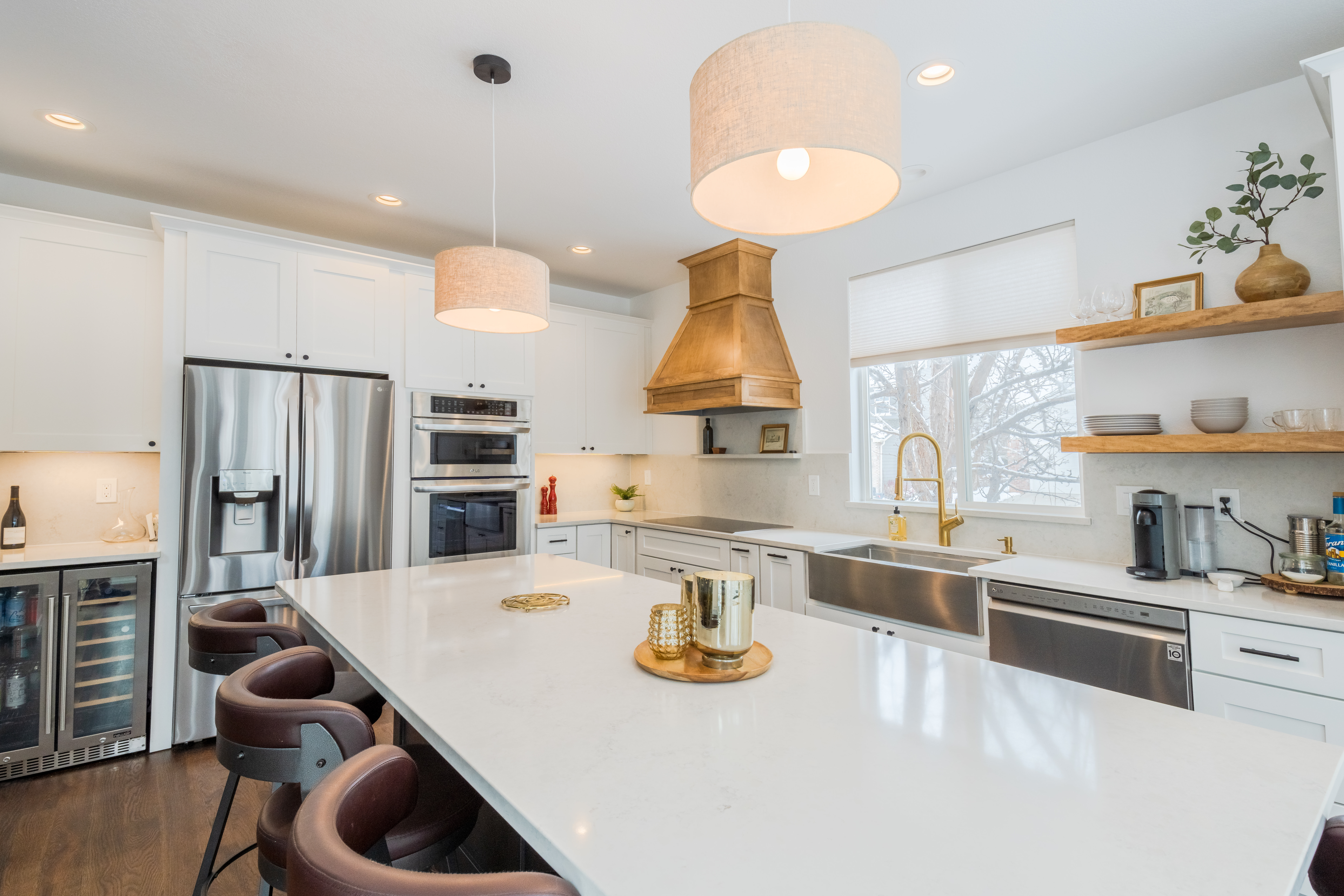 A new kitchen island stands at the center of a new kitchen remodel, lit warmly with newly installed lighting.
