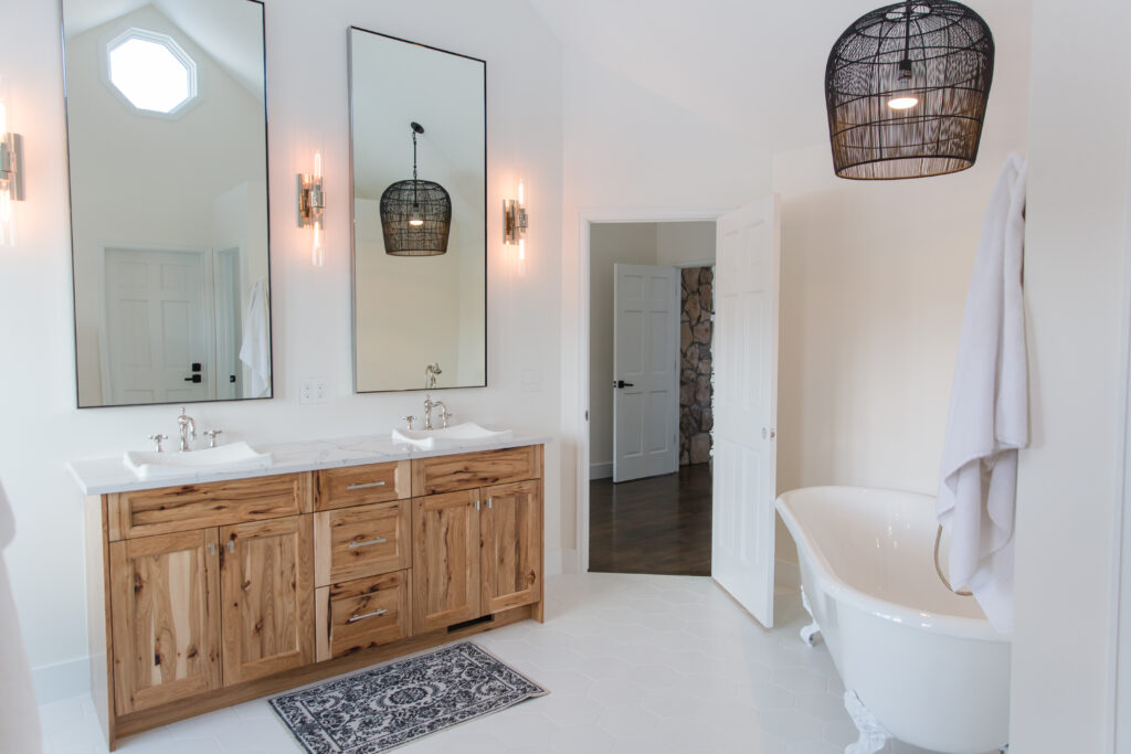 Newly remodeled bathroom in Colorado home, including a custom vanity, clawfoot tub, and custom lighting.